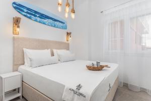 sypialnia z dużym białym łóżkiem i oknem w obiekcie Alpha & Omega w mieście Karpatos