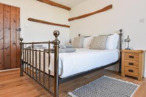 a bedroom with a bed and a wooden floor at Tithe Barn a Stunning family home with panoramic views in Ryde