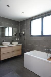 ® L'imprenable - Somptueuse villa vue mer في مارسيليا: حمام مغسلتين وحوض ومرايا