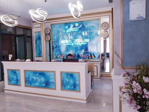 a lobby with a large display case with blue paintings at Gold Tbilisi Hotel in Tbilisi City