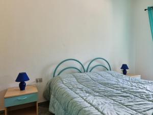 sypialnia z łóżkiem i 2 lampkami na stołach w obiekcie Residenza Cugnana w mieście Agrustos