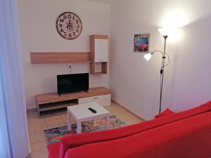 een woonkamer met een rode bank en een tv bij Apartment Suzie Q - Intermezzo with sea view in Rabac