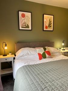 a bedroom with a bed and two pictures on the wall at Homely house at the foot of Snowdonia in Llanberis