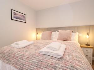 a bedroom with a large bed with two towels on it at Adas Hideaway in Kendal
