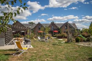 a group of chairs sitting in the yard of a house at Le jardin des 4 saisons in Le Mans