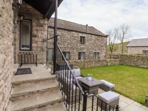 an external view of a stone house with a patio at Adas Hideaway in Kendal