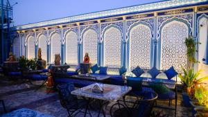 un restaurante con sillas y mesas azules frente a un edificio en Hotel Kalyan en Jaipur