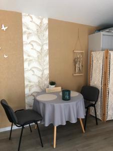 een kamer met een tafel en 2 stoelen bij Au Petit C'Alain in Toulouse