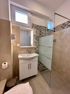 La salle de bains est pourvue d'un lavabo et d'une douche. dans l'établissement Bella House Nikiti, à Nikiti