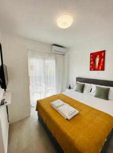 - une chambre avec un grand lit et une couverture orange dans l'établissement Bella House Nikiti, à Nikiti