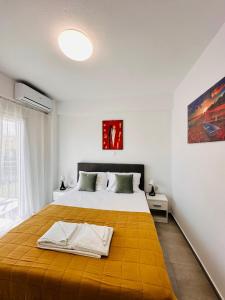 - une chambre avec un grand lit et une couverture jaune dans l'établissement Bella House Nikiti, à Nikiti