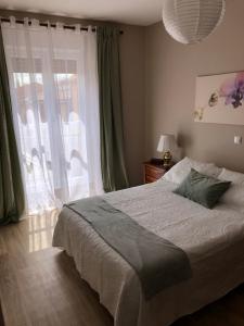 a bedroom with a bed and a large window at Casa Belia in Mansilla de las Mulas
