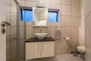 uma casa de banho com um lavatório, um chuveiro e um WC. em Gouriqua 401 em Mossel Bay