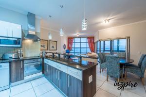 a kitchen with blue cabinets and a table and chairs at Gouriqua 401 in Mossel Bay