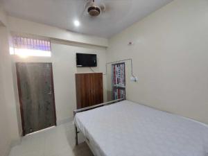 a bedroom with a bed and a flat screen tv at OYO The Pine & Dine in Sonpur