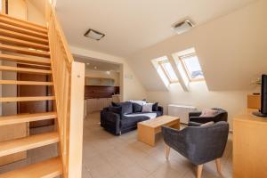 a living room with a couch and a staircase at Apartamenty Sun Seasons 24 - Bałtyckie in Rewal