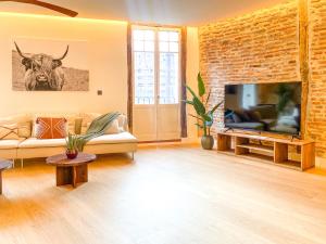 a living room with a brick wall and a tv at Ribera AC by Staynnapartments in Bilbao