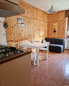 a kitchen with a stove and a table and a couch at Scoiattolo Apartment in San Martino di Castrozza
