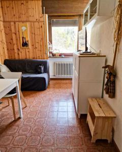 a living room with a refrigerator and a table at Scoiattolo Apartment in San Martino di Castrozza