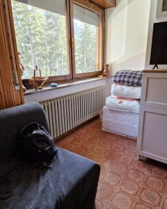 a room with a backpack sitting on a couch at Scoiattolo Apartment in San Martino di Castrozza
