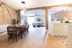 cocina y comedor con mesa y sillas en Ribera AC by Staynnapartments, en Bilbao