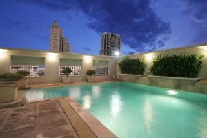 a large swimming pool with a city skyline in the background at Cape House Hotel, Bangkok in Bangkok