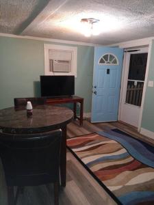 a living room with a table and a blue door at Cute 1 Bdrm House that sleeps 3 in Petersburg