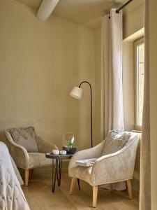 格里尼昂的住宿－Jas des roches，一间卧室配有两把椅子、一张桌子和一个窗户。