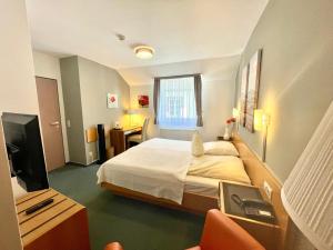 a hotel room with a bed and a television at Hotel Saarburger Hof in Saarburg
