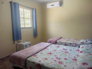 een slaapkamer met 2 bedden en een raam bij Casa Azul in Barreirinhas