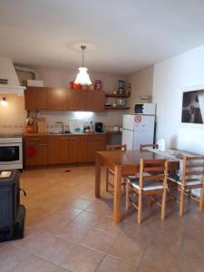 a kitchen with a table and chairs and a refrigerator at Casa do Moleiro in Santiago do Cacém