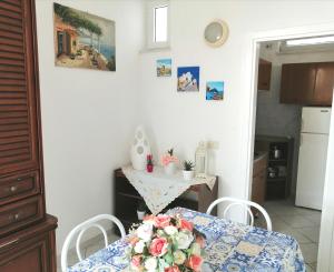una cucina con tavolo e fiori di Casa La Posidonia a Ischia