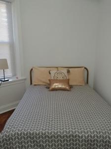 uma cama com um edredão cinzento num quarto em Logan Square Modern Apartment em Chicago