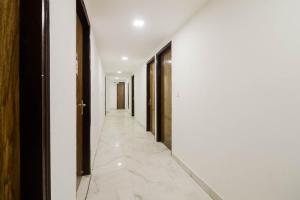 korytarz z białymi ścianami i białymi podłogami wyłożonymi kafelkami w obiekcie Flagship Gour Plaza w Nowym Delhi