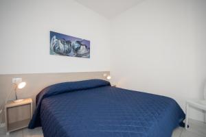 ビビオーネにあるCondominio Nautilusのベッドルーム1室(青い掛け布団付)