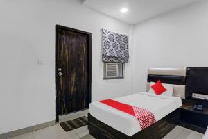 1 dormitorio con cama, ventana y puerta en Capital O Affection Inn, en Chinhat