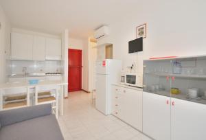 ビビオーネにあるCondominio Nautilusの白いキャビネットと赤いドア付きのキッチン