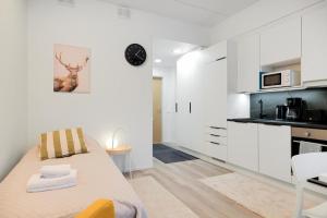 una cucina bianca con un letto in una camera di Forenom Serviced Apartments Espoo Saunalahti a Espoo