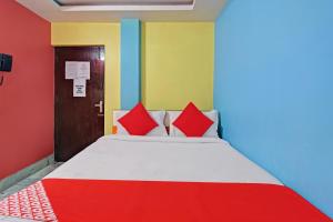 1 dormitorio con 1 cama con paredes rojas y azules en Flagship Continental Stays Near Netaji Subhash Chandra Bose International Airport, en Gauripur