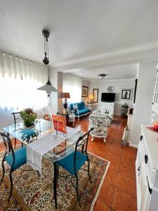 uma sala de estar com uma mesa e cadeiras azuis em Cocas House - Alcobaça em Alcobaça