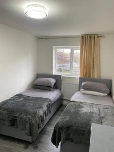 um quarto com 2 camas e uma janela em 2 bed house sleeps 4-5 em Liverpool