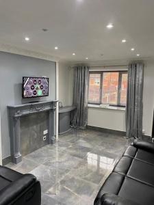 a living room with a couch and a flat screen tv at 2 bed house sleeps 4-5 in Liverpool