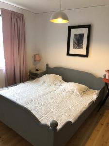 a bedroom with a bed with a white comforter at Anna Gården, App. D in Ytterhogdal