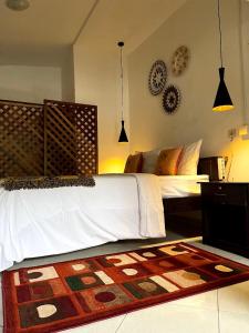 a bedroom with a bed and a rug on the floor at Summer Homestay Bali in Nusa Dua