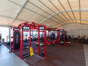 Un gimnasio con aparatos rojos en una carpa. en Sun city lifestyle, en Poreč