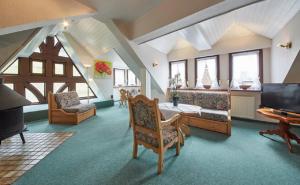 a living room with a couch and a tv and chairs at Gästehaus Zur Traube in Reil