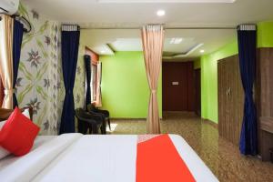um quarto com uma cama e uma parede verde em OYO Flagship 76044 Layeeree Resort em Bālianta