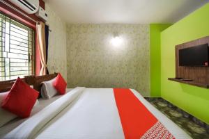 um quarto com uma cama com paredes vermelhas e verdes em OYO Flagship 76044 Layeeree Resort em Bālianta