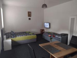 a living room with two beds and a table at Apartmány Borská in Karlovy Vary