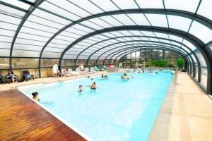 - une grande piscine avec des personnes à l'eau dans l'établissement Camping Les Carolins, à Saint-Lo-dʼOurville